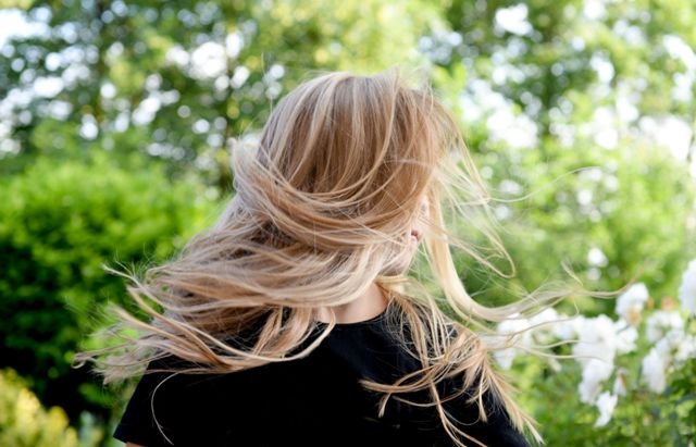 Blonde highlighted hair captured mid-motion outdoors