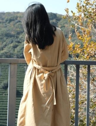 Camel cotton-gabardine trench coat worn as a layering piece for cool fall evenings