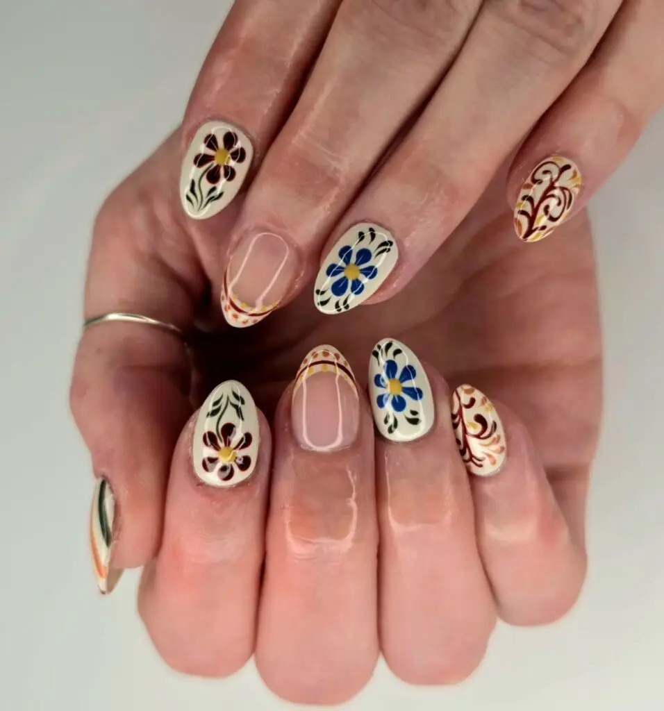 Cream nails with hand-painted blue and burgundy floral folk art