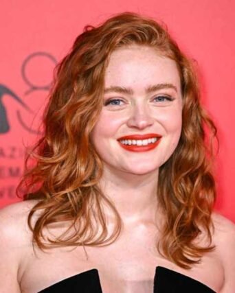 Curly red hair complemented by bold red lipstick on the red carpet