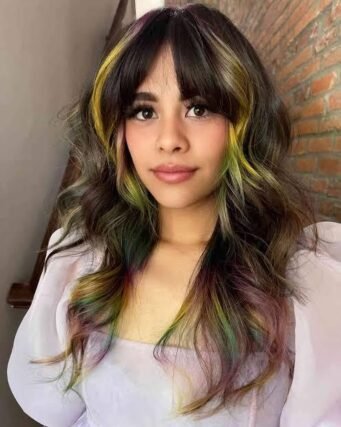 Dark hair with colorful pink and green face-framing highlights and bangs