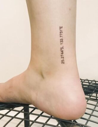 Fine-line geographic coordinates tattoo on inner ankle