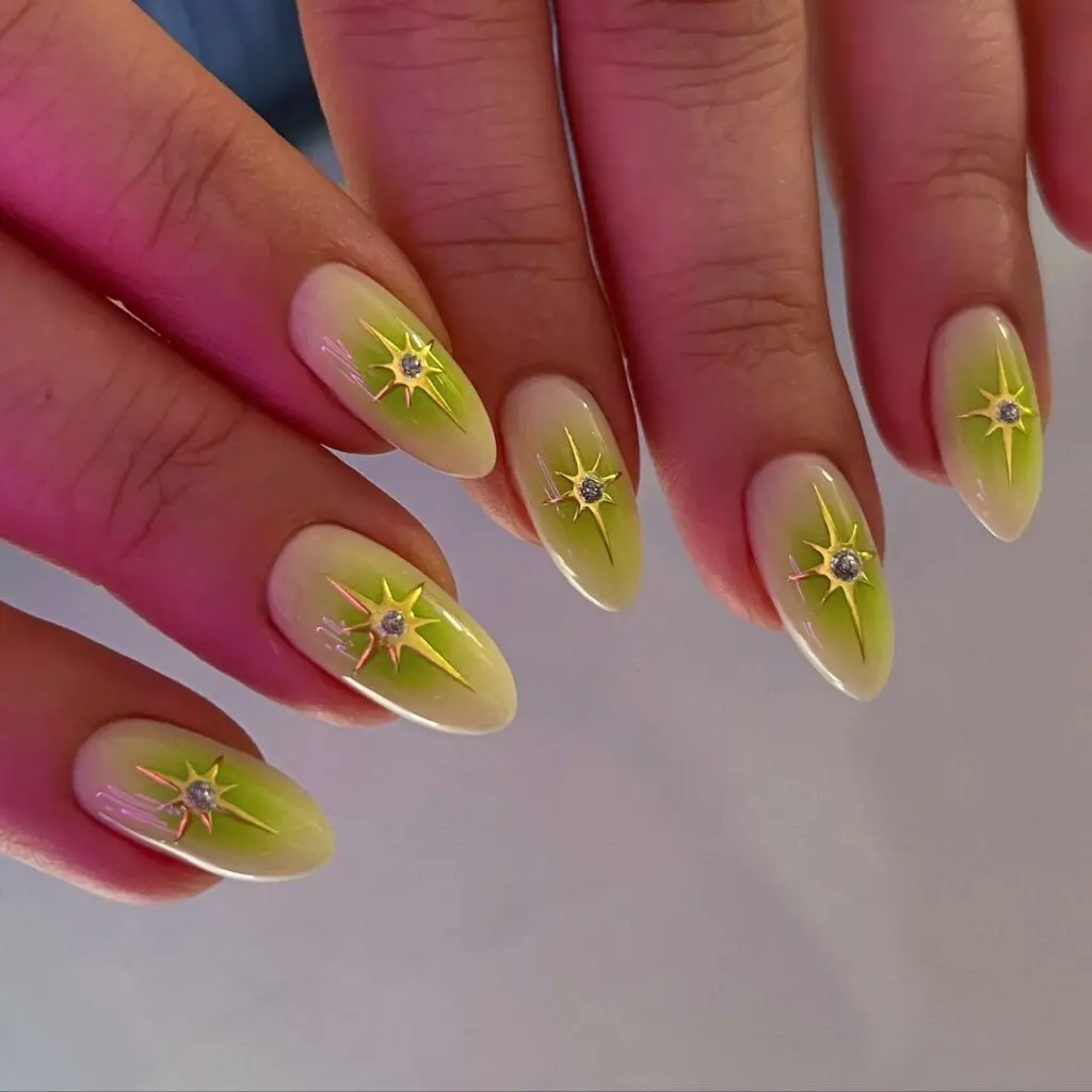 Green ombre almond nails with gold starburst rhinestone accents