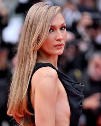 Long blonde balayage hair styled in a black dress on the red carpet