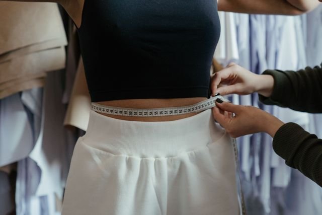 Close-up of a waist being measured with a tape measure for clothing fit
