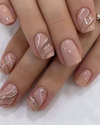 Nude nail art with hand-painted gold and white swirl watercolour design