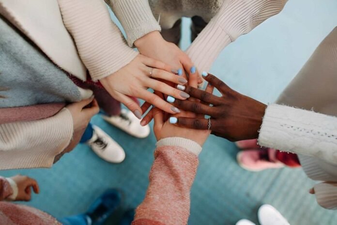 Group of hands with different manicure colours coming together