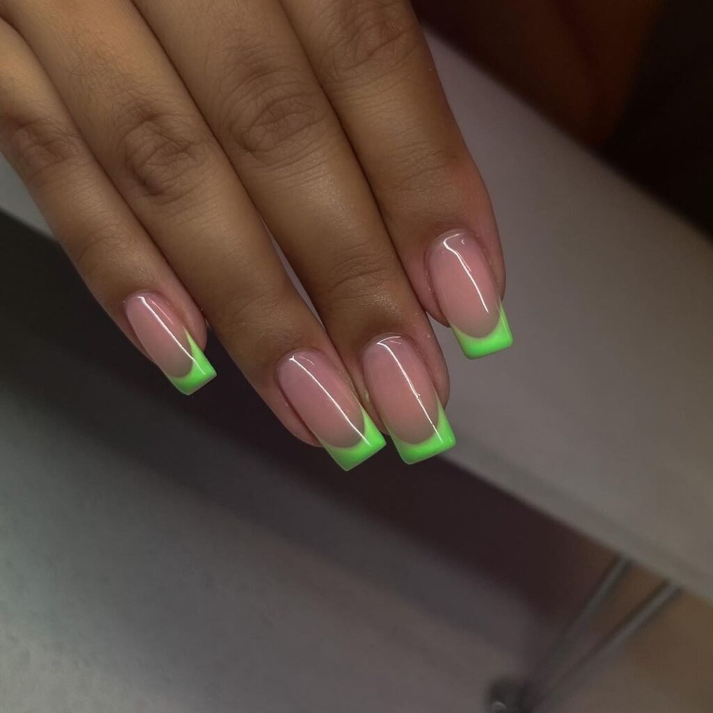 Neon green French tip nails on a nude base