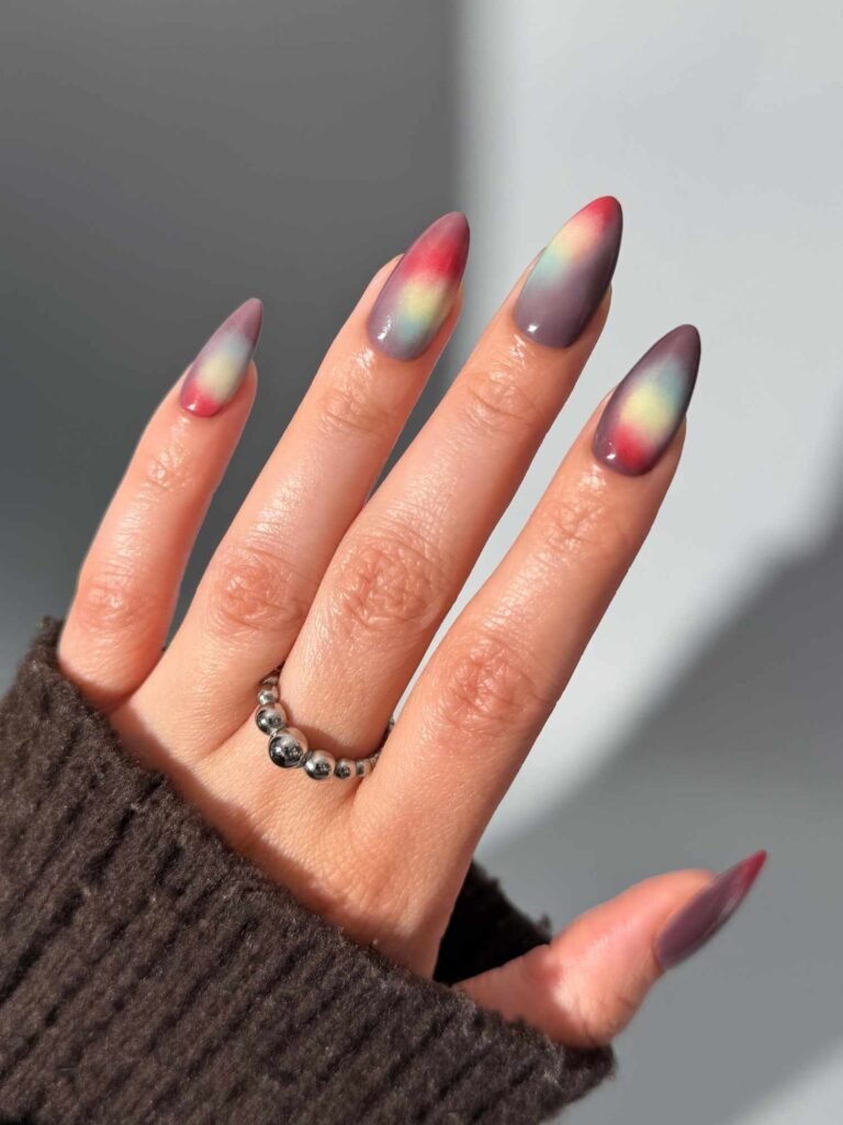 Almond-shaped nails with a red, purple, and yellow sunset-inspired aura design