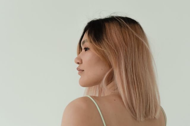 Woman with rose gold balayage hair color shown in profile
