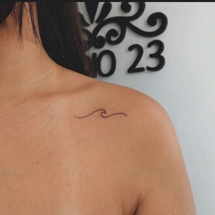 Minimalist wave line tattoo on collarbone for women