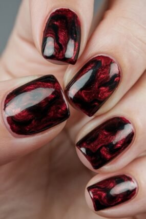 Abstract French manicure with red black and white swirls