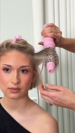Blow-drying a short gray bob with a paddle brush on damp hair